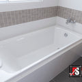 White bathtub in a bathroom with tiled walls and a visible brand logo.