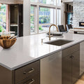 Modern kitchen with white countertops and stainless steel appliances